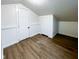 Finished attic with hardwood floors, neutral walls, and white storage doors at 5103 E St Clair St, Indianapolis, IN 46219