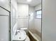 Bright white bathroom featuring a vanity, sink, toilet and tiled shower with window at 5103 E St Clair St, Indianapolis, IN 46219