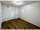 Bedroom with wood floors, two white closet doors, and a window at 5103 E St Clair St, Indianapolis, IN 46219