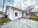 Charming white home showcasing a spacious driveway, covered porch, and neat landscaping at 5103 E St Clair St, Indianapolis, IN 46219
