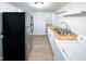 Kitchen with stainless steel refrigerator, butcher block counters, white cabinets, laundry, and stairs nearby at 5103 E St Clair St, Indianapolis, IN 46219