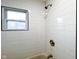 Modern white tile shower with bronze shower head and fixtures and window at 5103 E St Clair St, Indianapolis, IN 46219