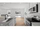 Bright white kitchen features an island with a sink, stainless steel appliances, and wood floors at 5119 Rolling Meadow Blvd, Indianapolis, IN 46237