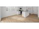 Bright white kitchen features an island with a sink, stainless steel appliances, and wood floors at 5119 Rolling Meadow Blvd, Indianapolis, IN 46237