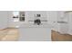 Bright white kitchen features an island with a sink, stainless steel appliances, and wood floors at 5119 Rolling Meadow Blvd, Indianapolis, IN 46237