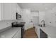 Bright white kitchen features an island with a sink, stainless steel appliances, and wood floors at 5119 Rolling Meadow Blvd, Indianapolis, IN 46237