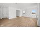 Open-concept living room featuring wood-look flooring, white walls, bright windows, and neutral decor at 5119 Rolling Meadow Blvd, Indianapolis, IN 46237