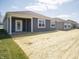 A view of the house with a simple backyard featuring fresh sod and an covered entry porch at 5146 Cartland Dr, Indianapolis, IN 46239