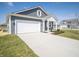 Well-built home featuring gray siding, white trim, an attached garage, and a concrete driveway at 5146 Cartland Dr, Indianapolis, IN 46239