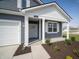 Close-up of the front exterior featuring gray siding, a white-framed window, and a charming front entry at 5146 Cartland Dr, Indianapolis, IN 46239