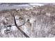 Aerial view showing the house on a wooded lot with a glimpse of the nearby lake beyond the canopy of trees at 6842 Cardinal Dr, McCordsville, IN 46055