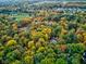 Aerial view of a wooded neighborhood with trees in fall colors and rooftops peeking through the canopy at 6842 Cardinal Dr, McCordsville, IN 46055
