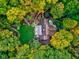 Aerial view of estate grounds with a home surrounded by meticulously landscaped gardens and colorful trees at 6842 Cardinal Dr, McCordsville, IN 46055