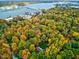 Aerial view of a neighborhood with trees in fall colors, a bridge and waterway in the background at 6842 Cardinal Dr, McCordsville, IN 46055
