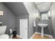 Stylish half bathroom with a pedestal sink, hardwood floors, and modern fixtures at 6842 Cardinal Dr, McCordsville, IN 46055