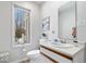 Well-lit bathroom features a vanity with a wooden trim, a modern mirror, and a view from the window at 6842 Cardinal Dr, McCordsville, IN 46055