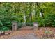 Gated entrance to Cardinal Woods. The brick pillars feature the address and neighborhood name surrounded by lush foliage at 6842 Cardinal Dr, McCordsville, IN 46055