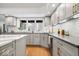 Bright kitchen features light gray cabinets, gold hardware, granite counters, and a window overlooking the backyard at 6842 Cardinal Dr, McCordsville, IN 46055
