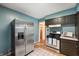 Kitchen with stainless steel refrigerator, gas range, and blue accent wall at 6865 Meadow View Dr, Lawrence, IN 46226