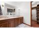 Large bathroom with a double vanity, mirror, tiled floors, and a doorway to a walk-in closet at 7018 W Anton Way, New Palestine, IN 46163