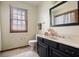 Well-lit bathroom features a modern vanity, toilet, large mirror, and window with blinds at 7018 W Anton Way, New Palestine, IN 46163
