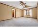 This empty main bedroom has a ceiling fan, neutral tones, carpet, and a window with natural light at 7018 W Anton Way, New Palestine, IN 46163