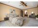 A stylish main bedroom featuring a tray ceiling, fan, carpeted floors, and ensuite bathroom access at 7018 W Anton Way, New Palestine, IN 46163