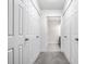 Hallway leading to a bathroom, with multiple closet doors at 8690 Jaffa Ct W Dr # 18, Indianapolis, IN 46260