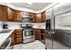 Well-lit kitchen featuring stainless steel appliances, wood cabinetry, and white subway tile backsplash at 8690 Jaffa Ct W Dr # 18, Indianapolis, IN 46260