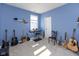 Bedroom with blue walls with natural light, an array of guitars, a keyboard and various instruments at 9208 Hawley Dr, Indianapolis, IN 46216