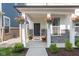 Welcoming front porch with charming hanging plants and tasteful landscaping, creating inviting curb appeal at 9208 Hawley Dr, Indianapolis, IN 46216
