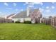 Lush backyard featuring a well-maintained lawn, beautiful flowering trees, and a privacy fence, ideal for outdoor relaxation at 11130 Sanabria Dr, Indianapolis, IN 46235