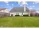 Expansive backyard with lush green grass, a privacy fence, mature landscaping, and a flowering tree at 11130 Sanabria Dr, Indianapolis, IN 46235