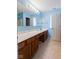 Bright blue bathroom features a large mirror, double sink vanity with wood cabinets and a shower/tub combo at 11130 Sanabria Dr, Indianapolis, IN 46235