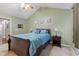 Vaulted ceilings accent the main bedroom featuring a wood sleigh bed, ceiling fan, carpet floors and ensuite bath access at 11130 Sanabria Dr, Indianapolis, IN 46235