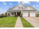 Charming home with a well-manicured lawn, attached two-car garage, and inviting front porch at 11130 Sanabria Dr, Indianapolis, IN 46235
