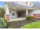Charming front porch with brick columns, hanging flower baskets, and double red doors at 11130 Sanabria Dr, Indianapolis, IN 46235
