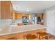 An eat-in kitchen offers wood cabinets, stainless steel appliances, an island with bar stool seating and wood laminate flooring at 11130 Sanabria Dr, Indianapolis, IN 46235