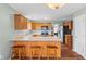 An eat-in kitchen offers wood cabinets, stainless steel appliances, an island with bar stool seating and wood laminate flooring at 11130 Sanabria Dr, Indianapolis, IN 46235