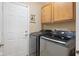 Convenient laundry room equipped with a modern washer and dryer, located near a storage cabinet at 11130 Sanabria Dr, Indianapolis, IN 46235