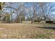 A spacious backyard with a large grassy area and a mature tree line, enclosed by a wooden fence at 1408 W Banta Rd, Indianapolis, IN 46217