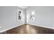 A bedroom featuring wood floors, light grey walls, white trim, and a window with a backyard view at 1408 W Banta Rd, Indianapolis, IN 46217