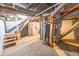 An unfinished basement with stairs, a hot water heater, and exposed rafters at 1421 Shepard St, Indianapolis, IN 46221