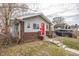 Cozy single-Gathering home featuring gray siding, brick foundation, and a vibrant red front door at 1421 Shepard St, Indianapolis, IN 46221