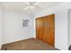 Bright bedroom features neutral carpet, a ceiling fan, a window, and closet with sliding wooden doors at 143 Sawmill Rd, Whiteland, IN 46184
