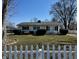 Charming ranch-style home with a well-maintained lawn, mature landscaping, and a classic white picket fence at 143 Sawmill Rd, Whiteland, IN 46184