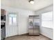 The kitchen features a stainless fridge, plenty of light, and access to an exterior door at 143 Sawmill Rd, Whiteland, IN 46184