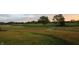 Scenic view of a lush golf course at sunset, featuring manicured greens, rolling hills, and mature trees in the background at 16473 Valhalla Dr, Noblesville, IN 46060