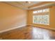 Spacious bedroom featuring gleaming hardwood floors and a large window overlooking the backyard at 1655 Rosebud Ln, Greenwood, IN 46143