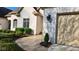 Classic white brick home featuring a beige garage door, lush landscaping, and refined outdoor lighting at 1655 Rosebud Ln, Greenwood, IN 46143